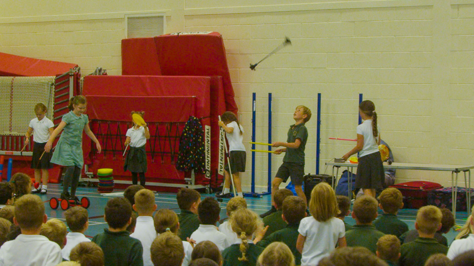 School children performing circus skills in school hall