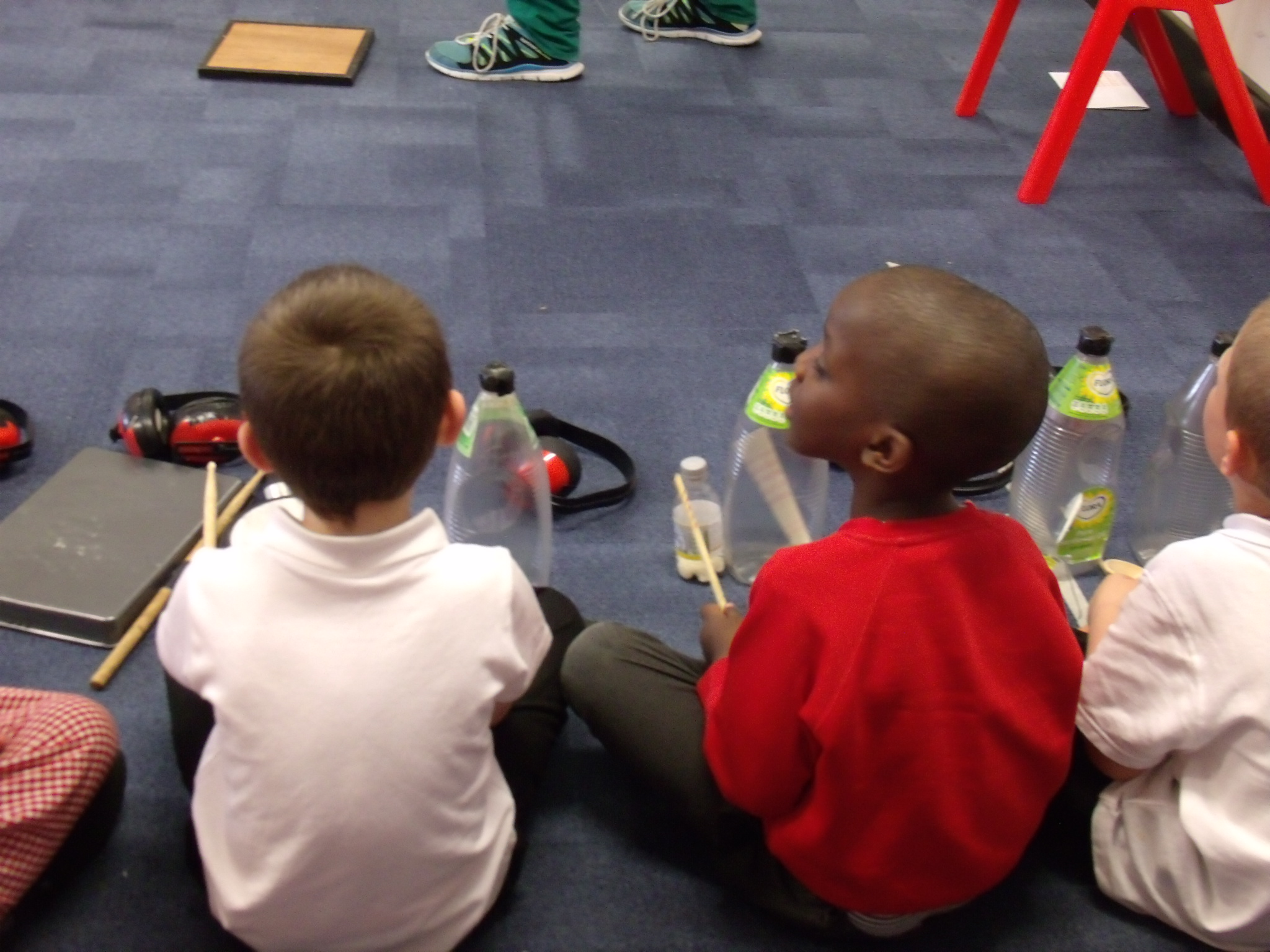 School children playing musical instruments made out of bottles