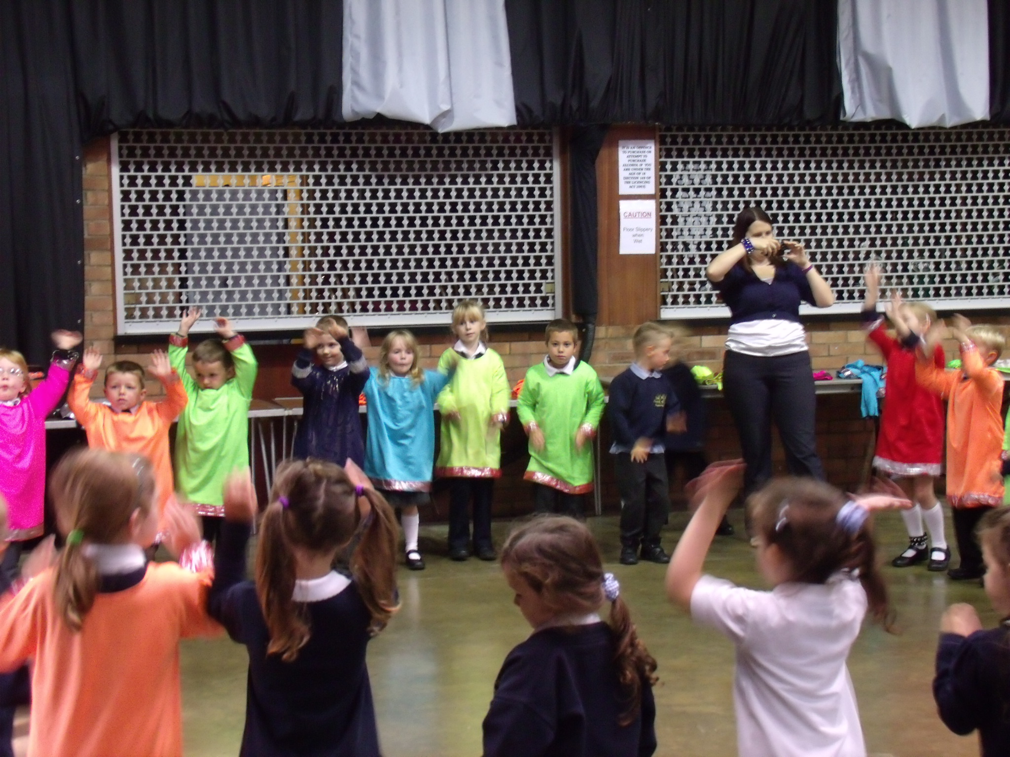 School children dressed in bright Indian clothing learning Indian dance