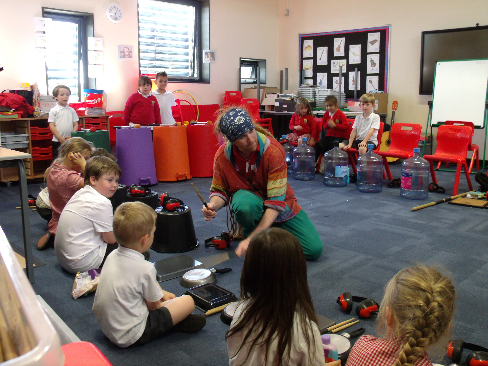 School children playing musical instruments made out of different objects