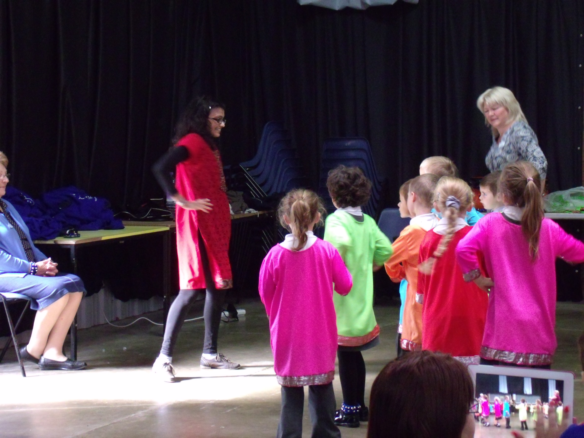 School children dressed in bright Indian clothing learning Indian dance