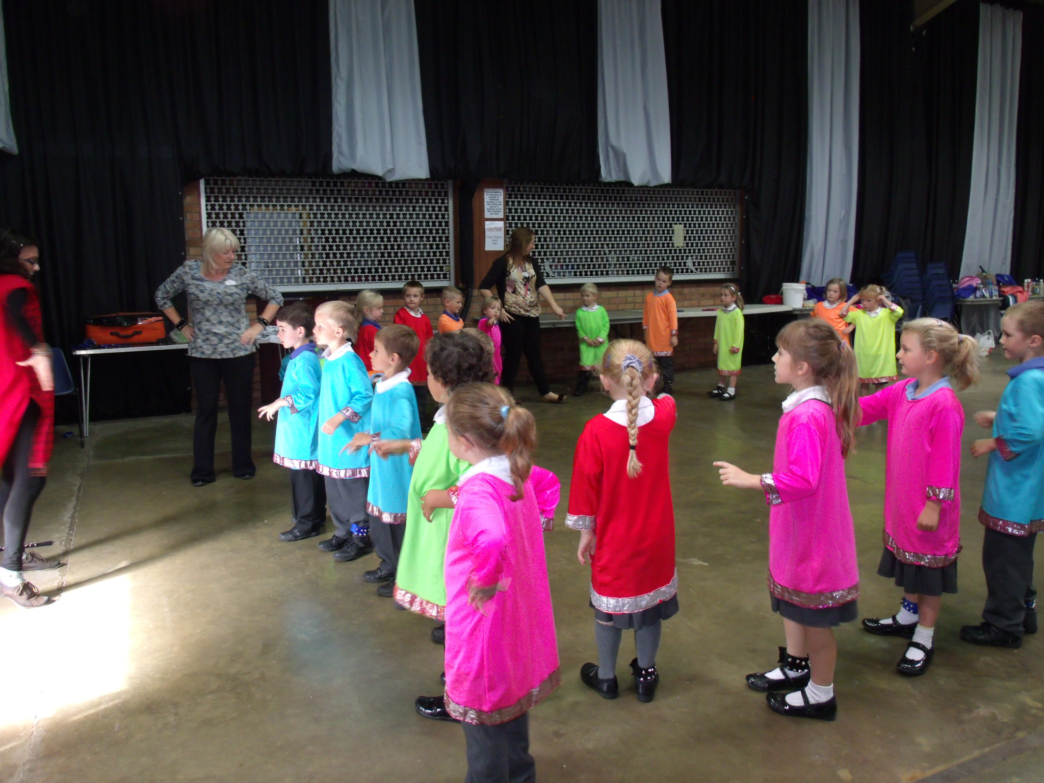 School children dressed in bright Indian clothing learning Indian dance