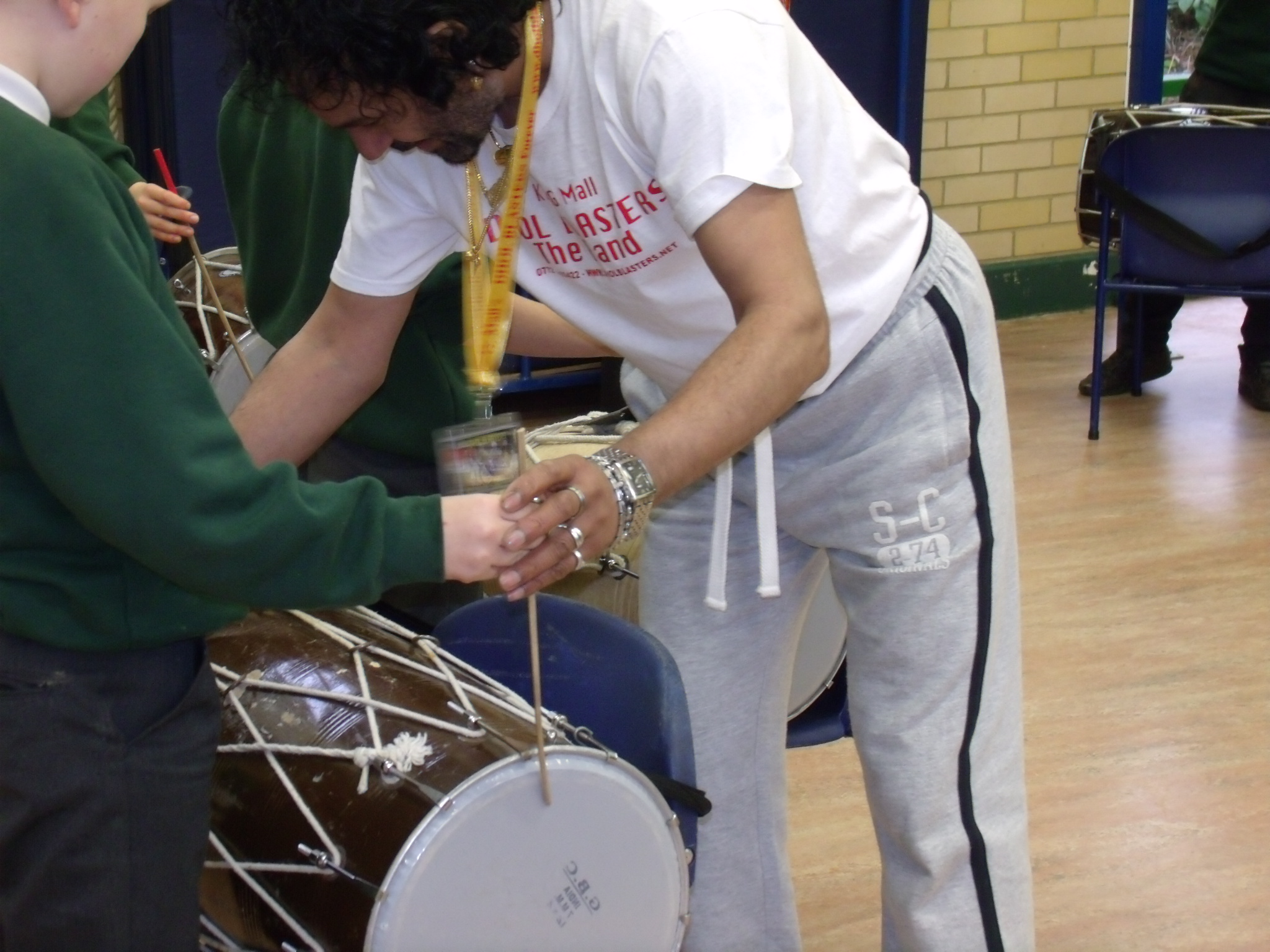 Class of children being taught how to use an Indian drum