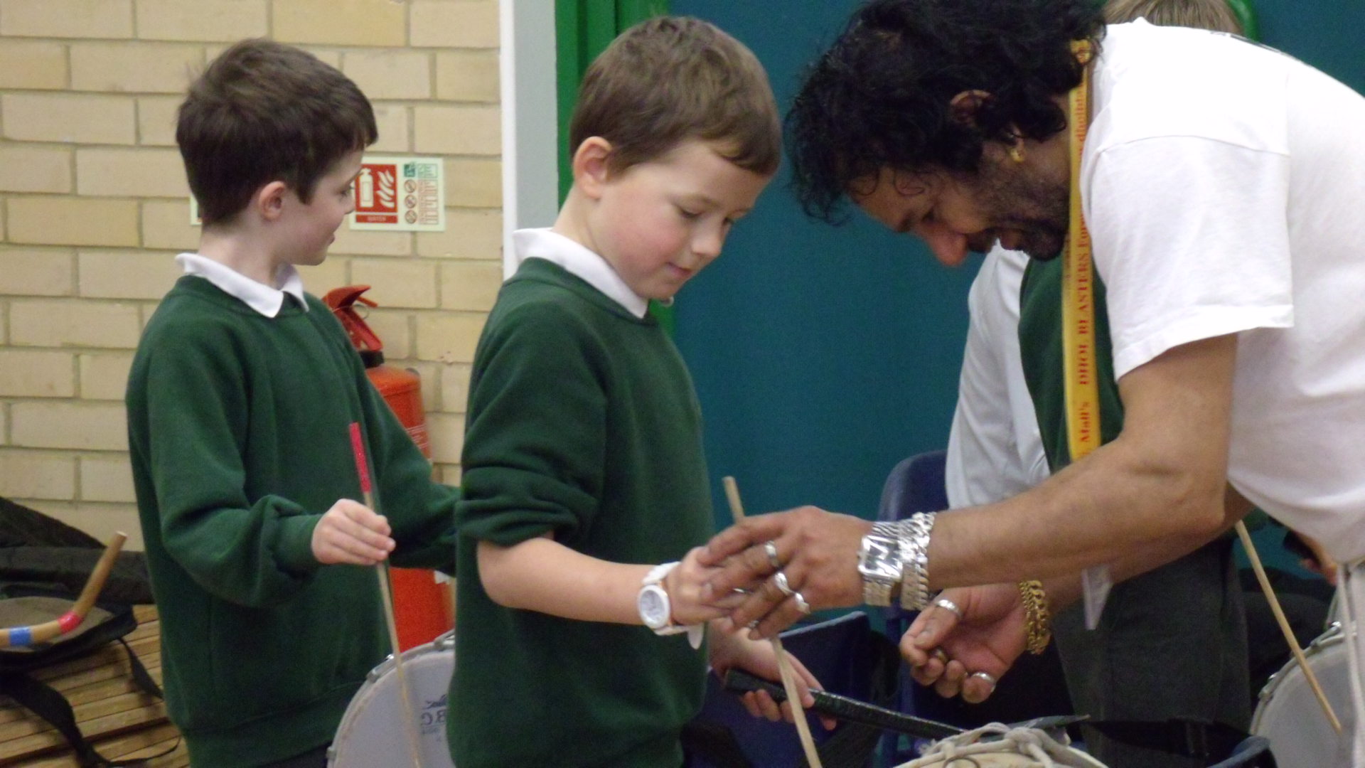 Teach demonstrating how to play Indian drum