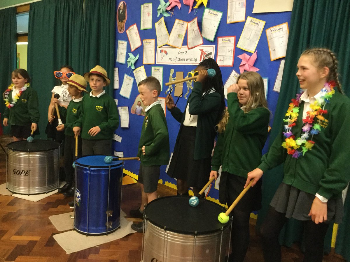 Teacher demonstrating to school children how to play Samba drums