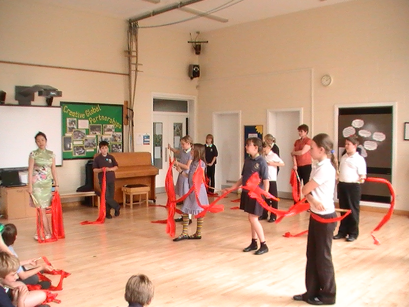 School children learning how to dance with Chinese dance ribbons