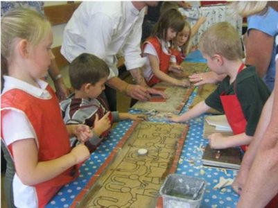 School children drawing out a design for a mosaic