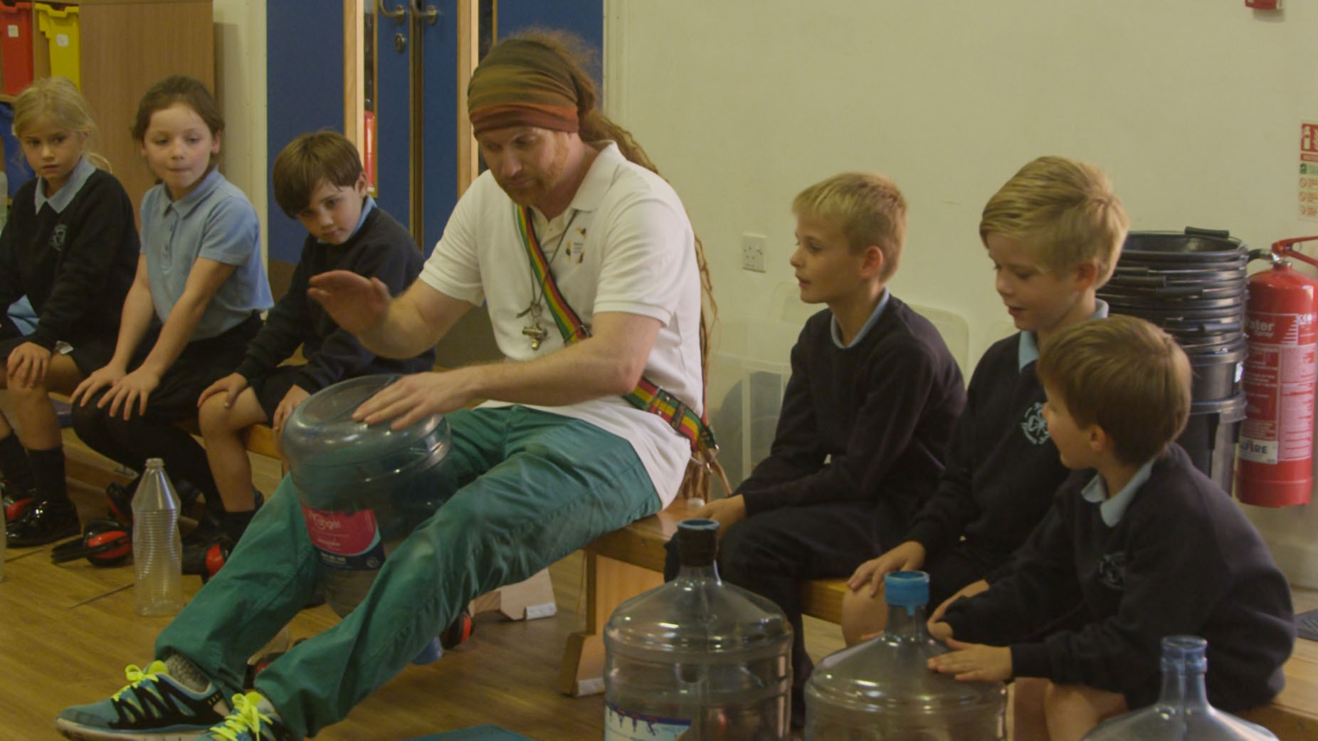 School children playing music on recycles household items