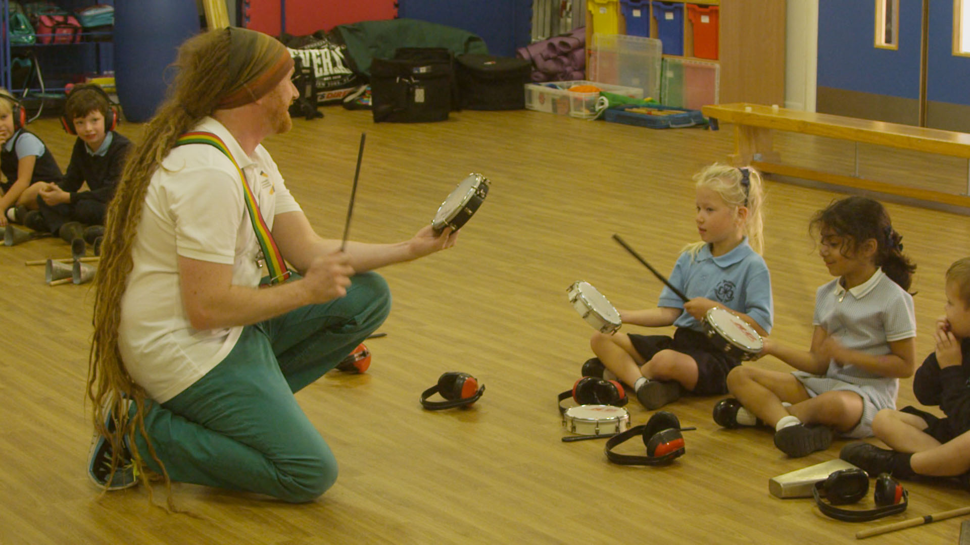 Teacher demonstrating to school children how to play Samba drums